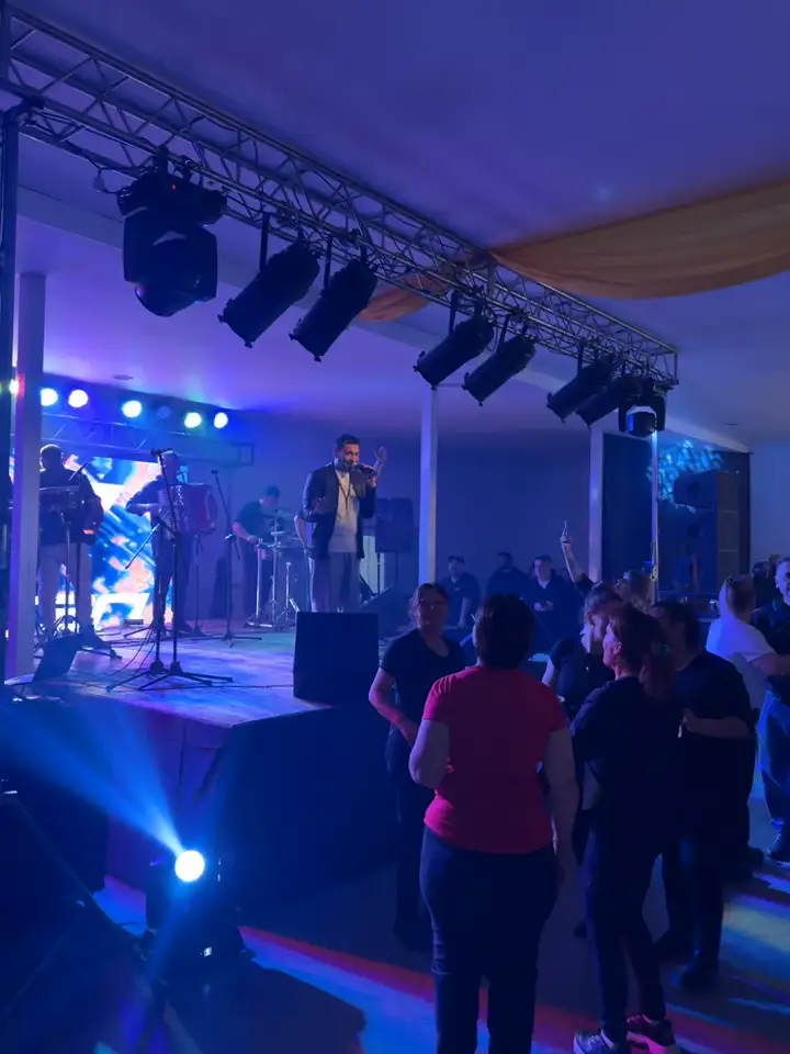 Truss con cabezales móviles sobre banda en vivo y gente bailando