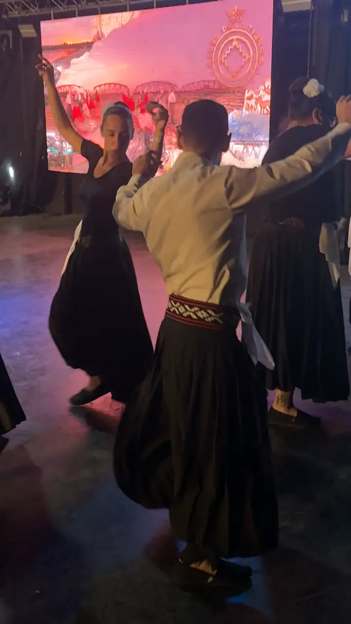 Parejas bailando frente a una gran pantalla LED