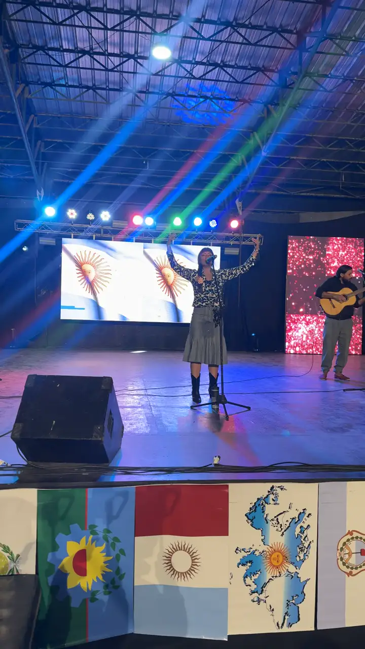 Escenario con pantalla LED, luces y line array durante un show en vivo